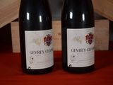 two bottles of wine sitting next to each other on a table