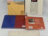 three books on a white surface with a white background