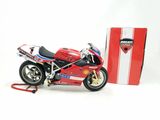 a red motorcycle that is next to a red box