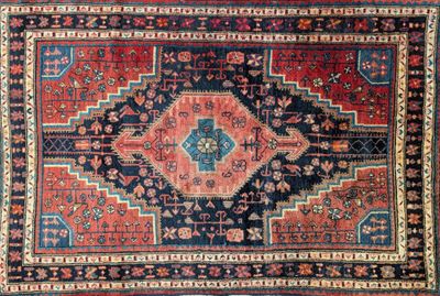 un gros plan sur un tapis oriental aux motifs rouges et bleus