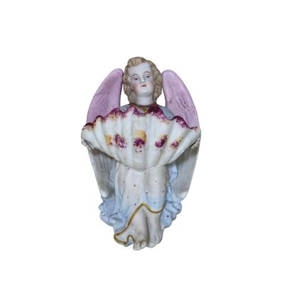 a figurine of an angel sitting on a white surface