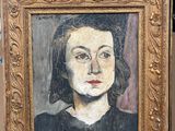 Un tableau représentant une femme en robe noire est posé sur un chevalet