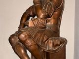 a bronze statue of a man sitting on a bench