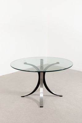 une table en verre avec une base en métal et un plateau en verre