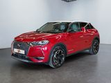 Un SUV rouge est garé dans une grande pièce