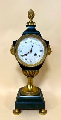a clock that is sitting on a stand on a table