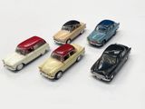 several toy cars are lined up in a row on a white surface