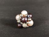 a close up of a ring with pearls on a black surface