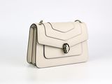 le petit sac blanc est posé sur une surface blanche