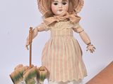 a doll with a hat and an umbrella next to a box