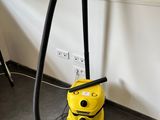 un aspirateur jaune posé par terre dans la pièce