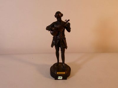 a bronze statue of a man playing a violin