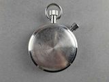 a silver pocket watch with a chain on a table