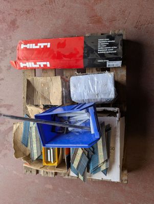 un tas d'outils posé sur une palette près d'un mur