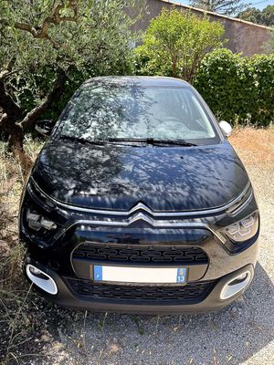 the front of a black citrole parked on a gravel road