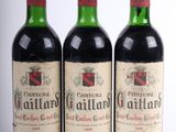 trois bouteilles de vin rouge posées l'une à côté de l'autre sur une surface blanche
