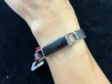 someone is wearing a bracelet with a black and red buckle on it