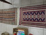 de nombreux tapis accrochés au mur dans une pièce