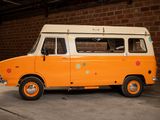an orange and white van parked in front of a brick wall