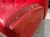 a close up of a red leather chair with rivets on the back