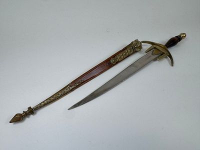 an old dagger is laying on a white surface next to a knife