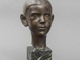 statue représentant la tête d'un garçon posée sur un bloc de marbre