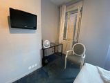 a room with a bed, chair, and television in it