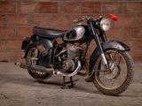 a black motorcycle parked in front of a brick wall