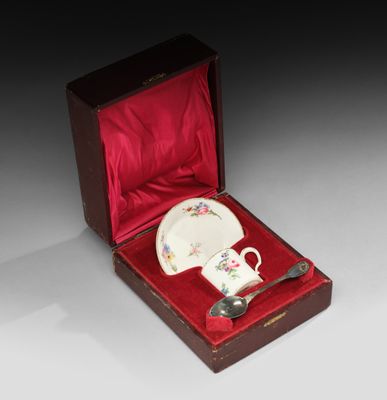 une petite tasse et une soucoupe dans une boîte rouge