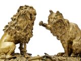 pair of antique bronze lions on a leafy base