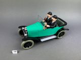 une figurine représentant un homme et une femme dans une voiture verte