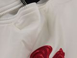 the back of a white shirt with a red rooster embroidered on it
