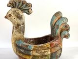 a colorful bird shaped planter sitting on a white surface