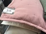 a pile of pillows on a table with a price tag on it