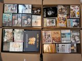 un grand nombre de dvd dans une boîte posée sur le sol