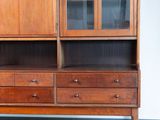 a wooden cabinet with two drawers and a glass door