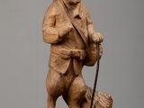 statue of a bear with a hat and a cane on a wooden block