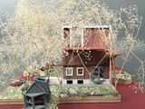a small model of a house on a red table