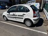 a small white car parked in a parking lot