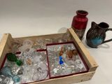 une caisse en bois remplie de bouteilles et de vases en verre