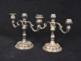 pair of antique silver plated candelabs on black background
