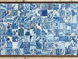 une photo d'une fresque en carreaux bleus et blancs sur un mur de briques
