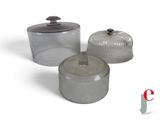 three glass containers sitting next to each other on a white surface