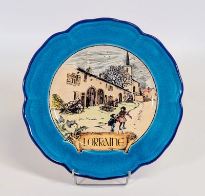 une assiette bleue sur laquelle est représenté un village