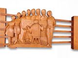 wooden sculpture of a group of people on a fence