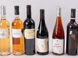 plusieurs bouteilles de vin sont alignées sur une surface blanche