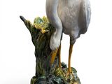 a statue of a bird that is standing on top of a tree stump