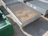 une grille métallique posée au sol à côté d'un bac vert