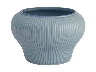 un vase bleu posé sur une surface blanche