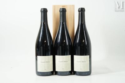 trois bouteilles de vin sont posées devant une caisse en bois